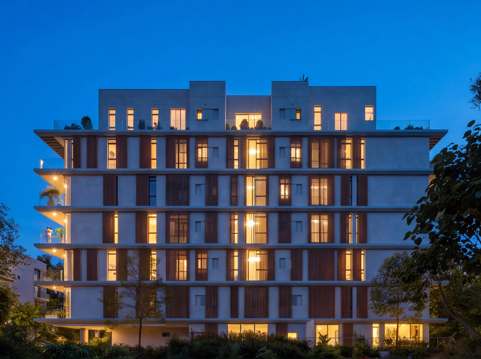 Kalischer 38 at night, the apartments lit behind timber louvres